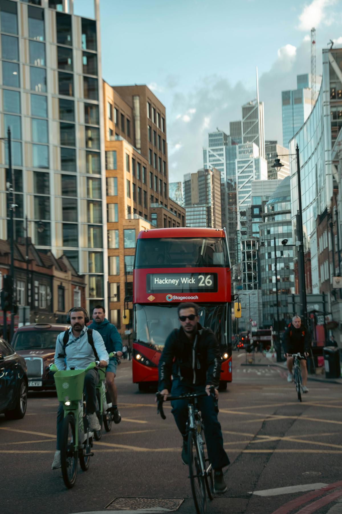 Busy London street with cyclists and a red bus, cycling towards Hackney from the City