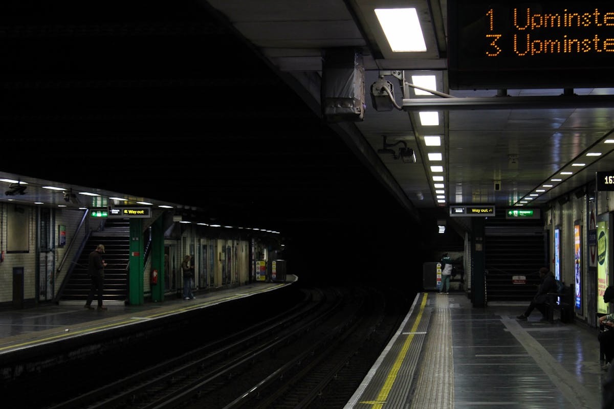 London Underground platform at night with passengers waiting for a train