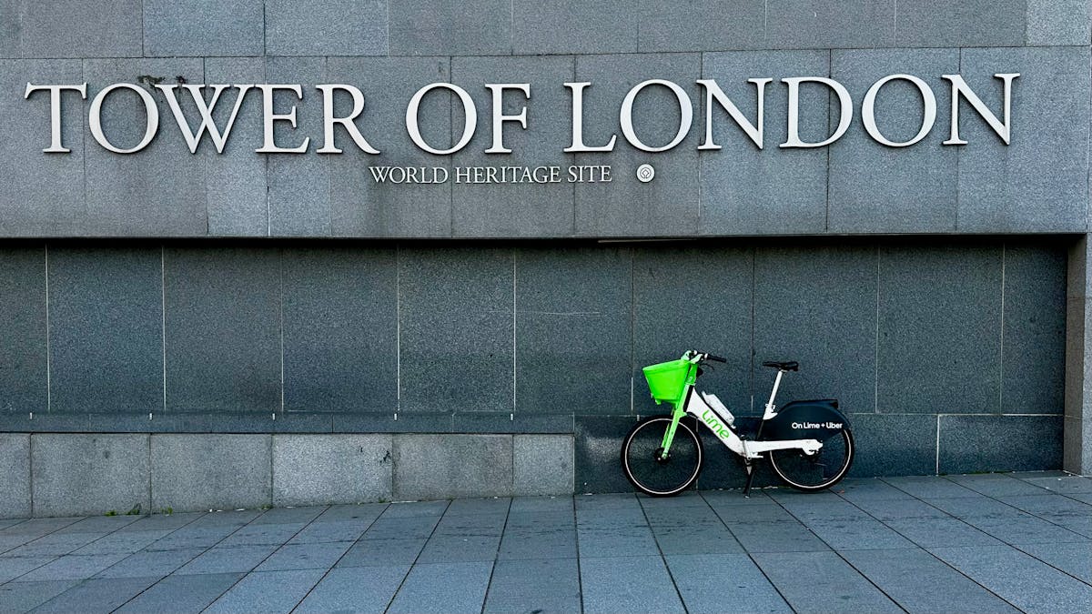 Bicycle parked next to a Tower of London sign