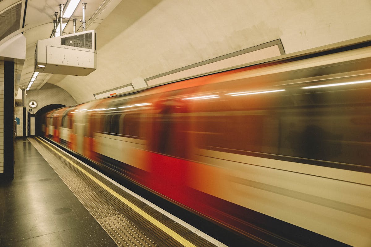 A London Underground train speeding through a station, captured with motion blur